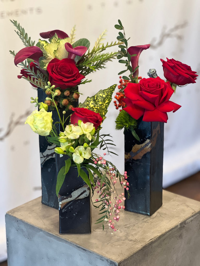 Trio with blossoms and greens in handmade vases