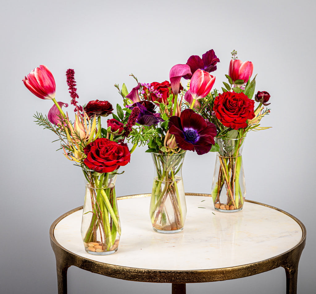 Tiny Trio with blossom and greens in petite glass vases