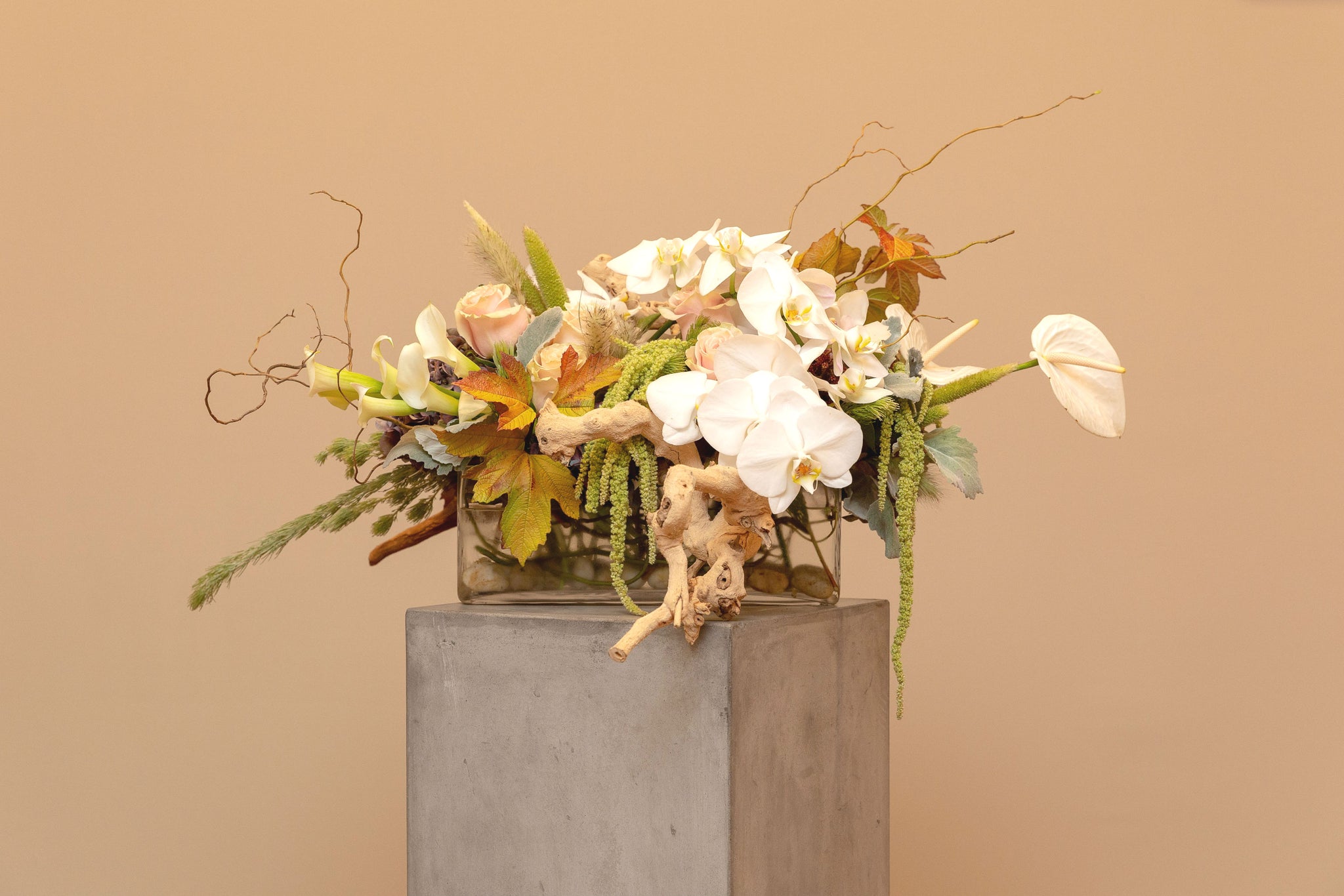 Natural, low, long, brimful floral mix, grape-wood, curly willow & rocks