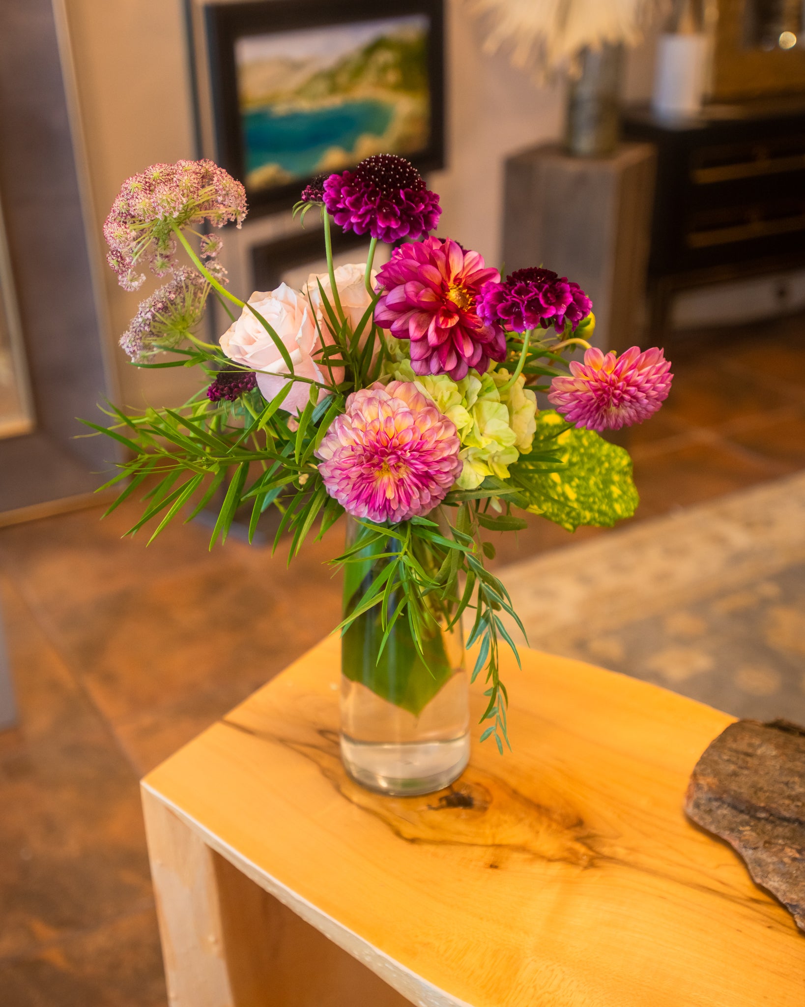 A compact yet brimful floral mix, slender glass vase