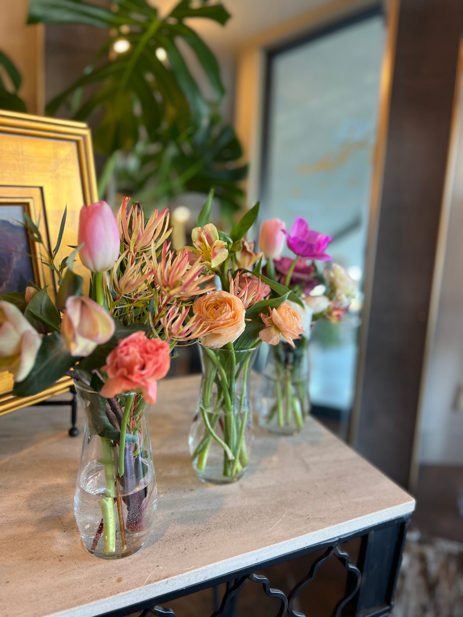 Tiny Trio with blossom and greens in petite glass vases