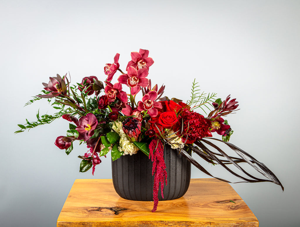 Cymbidium orchids, eclectic florals & foliage, textured black ceramic vase