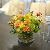 Lush & brimful, coiled foliage, circular vase with curly willow & rocks