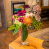 Compact yet brimful floral mix, slender glass vase