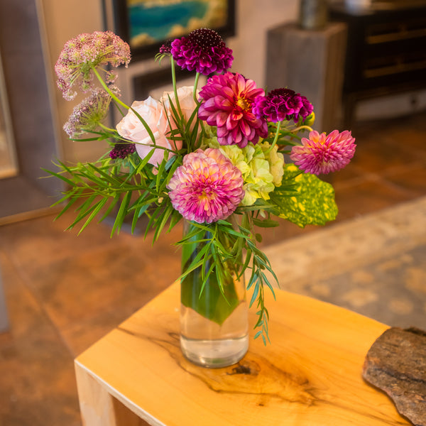 Compact yet brimful floral mix, slender glass vase